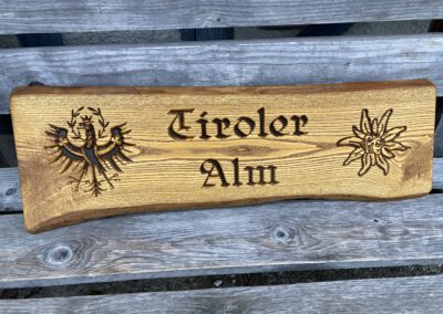 Rustikales Holzschild mit Naturkante vertieft dunkel Logo Adler Edelweiß Tiroler Alm