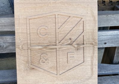 Ausgearbeitetes Firmenlogo rustikal geschnitzt Holz naturbelassen C&F