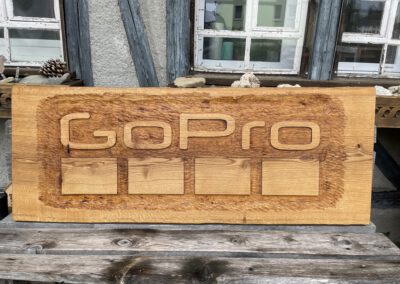 Rustikales geschnitzes Schild mit herausgearbeitetem Logo GoPro